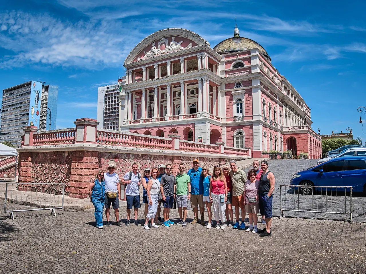 A group of clientes and friends with Mikkel standing in front of the pink Amazon Theatre