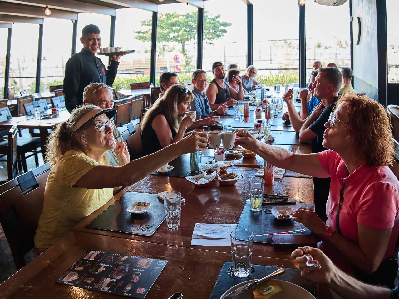 A group of friends at a restaurant toasting with drinks