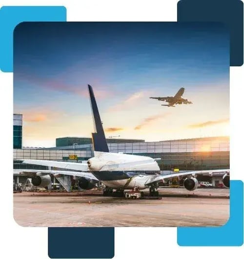 Airplane parked at the airport with another plane taking off at sunset, representing the Business Class membership travel experience.