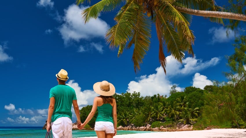 Pareja relajándose en una playa tropical en La Digue, Seychelles