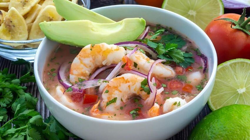 O ceviche equatoriano é feito com frutos do mar frescos, como camarão ou polvo, marinados em limão com tomate, cebola e coentro, geralmente servido com banana verde frita