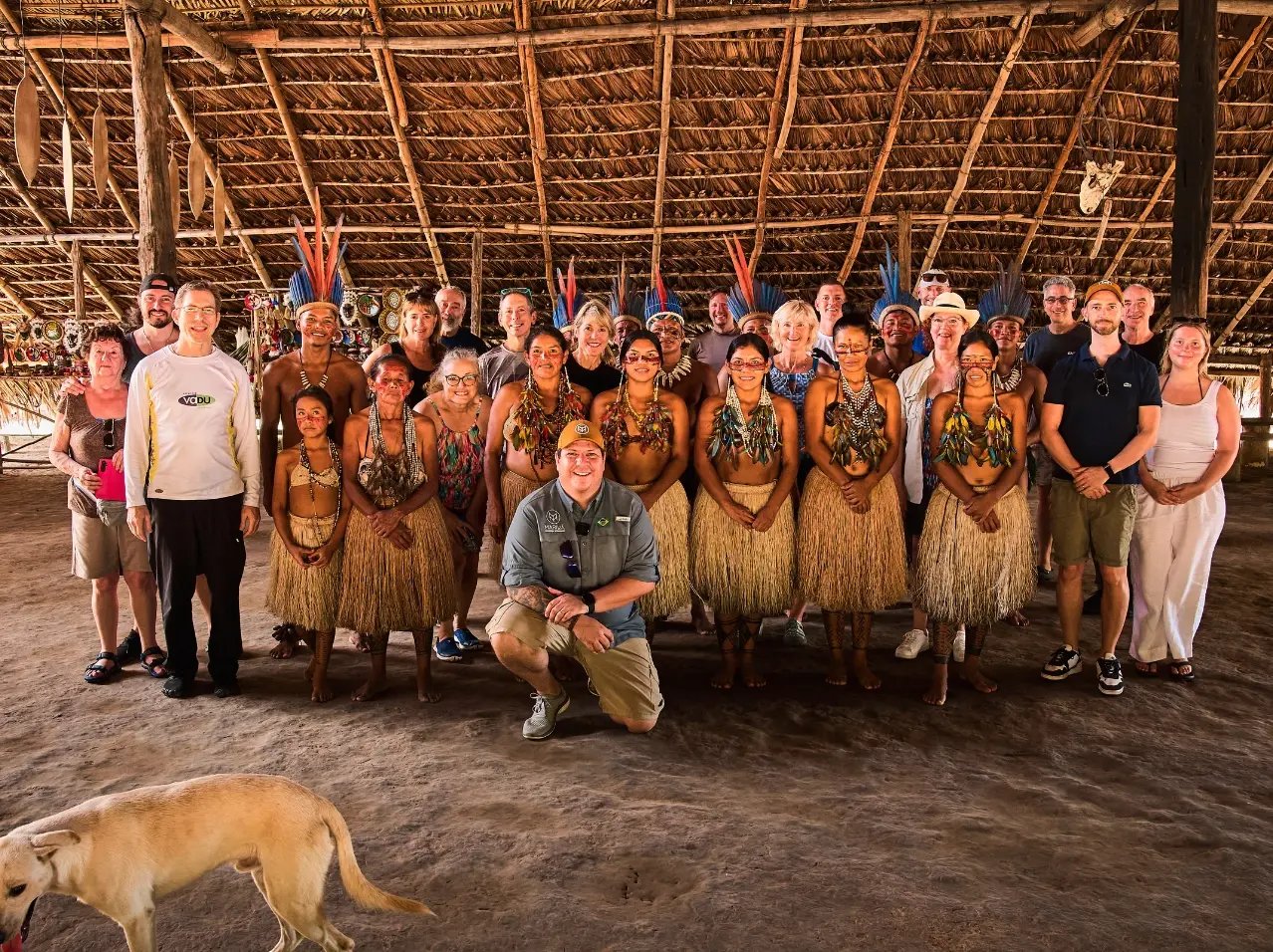 Mikkel and a group of clients and friends posing with an Indigenous community inside a building