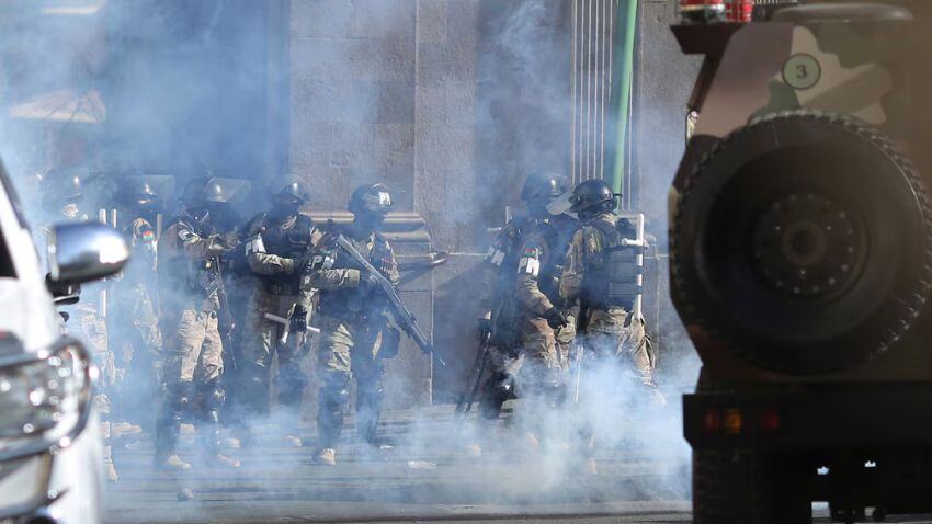 Policiais Militares caminham em meio a gás lacrimogêneo do lado de fora do palácio presidencial na Plaza Murillo em 26 de junho de 2024, em La Paz, Bolívia. (Gaston Brito Miserocchi/Getty)