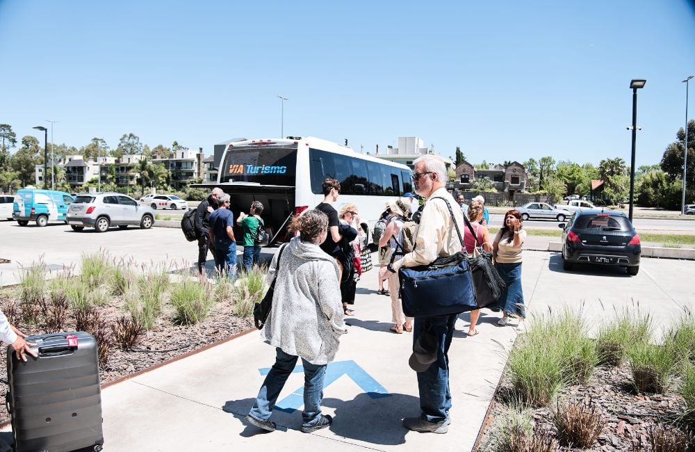 Our tour group getting ready to board a bus and storing their bags in the luggage compartment-1