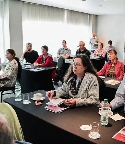 Participants attending an Expat Money conference session, listening attentively and taking notes.