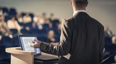 man standing lecturing to people-1