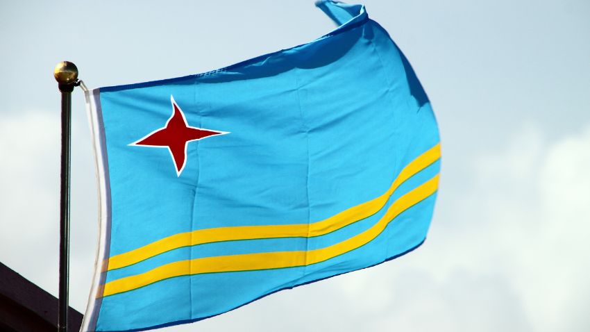 Flag of Aruba against the Sky -  For those seeking guidance or assistance during their stay, local agencies and guides are readily available to help digital nomads make the most of their Aruban vacation. 