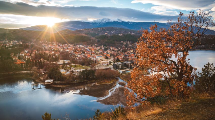 Hermosa puesta de sol cerca de Sofía, Bulgaria - Lago Pancharevo y árboles de otoño